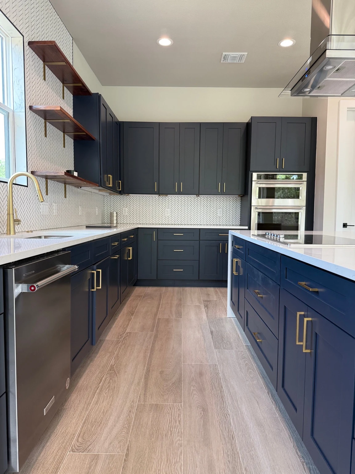 Navy kitchen with Carrara Quartz countertops, tile and cabinetry installed by StoneLux